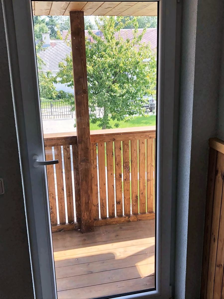 Dveře na dřevěný balkon s výhledem do zahrady