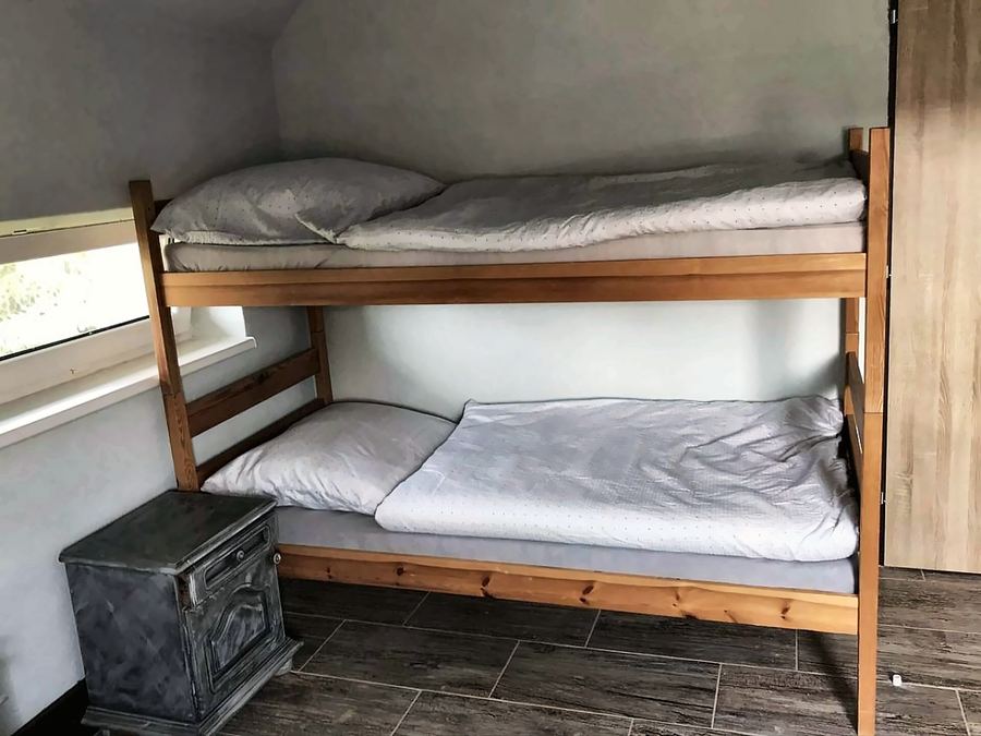 Dřevěná patrová postel u okna